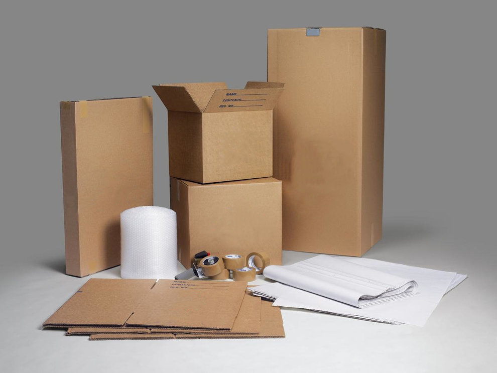 Rolls of flexible packaging film and printed labels on a production table