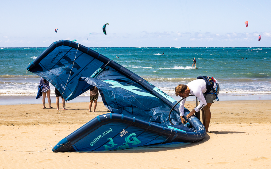 Station team preparing kitesurf equipment by the bay