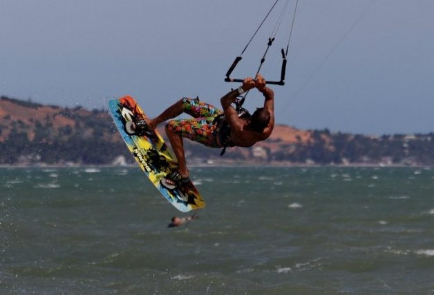 Kitesurfer riding across a bright windy bay