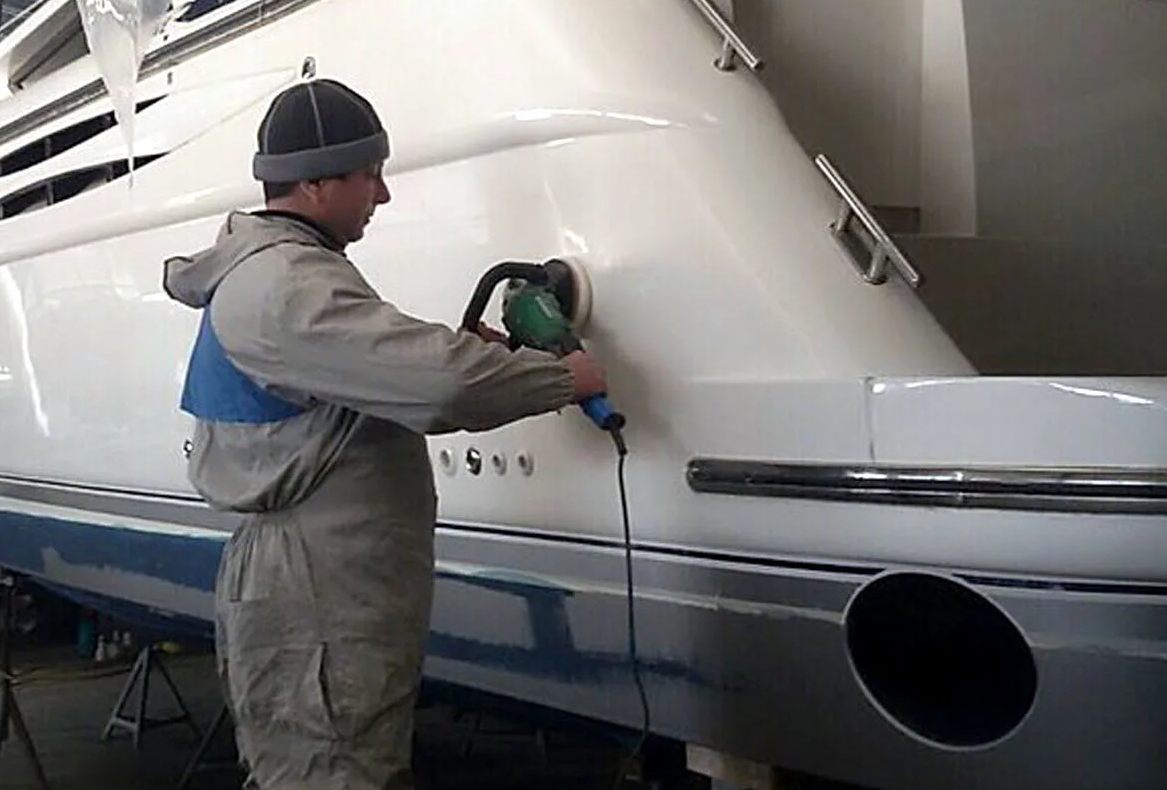 Marine repair specialists reviewing yacht damage in a dock facility