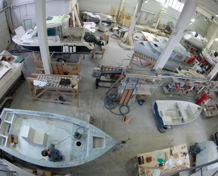 Composite yacht hull restoration and finishing inside a repair dock